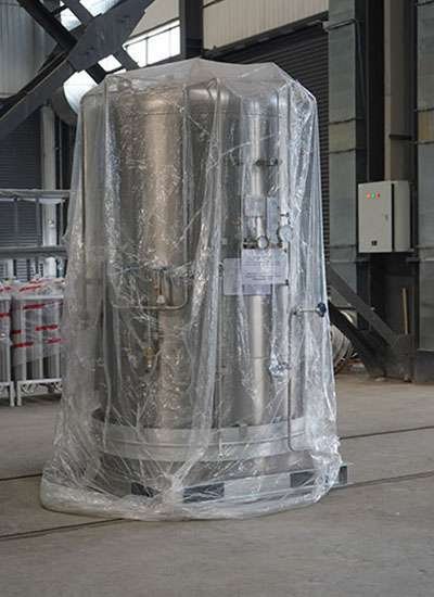 A cryogenic bulk tank of stainless steel covered in plastic packing, used for storing liquefied gases.