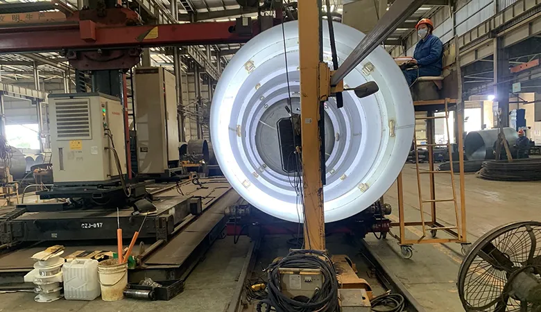 Welding process on the outer shell of a cryogenic tank during assembly in a controlled industrial environment.